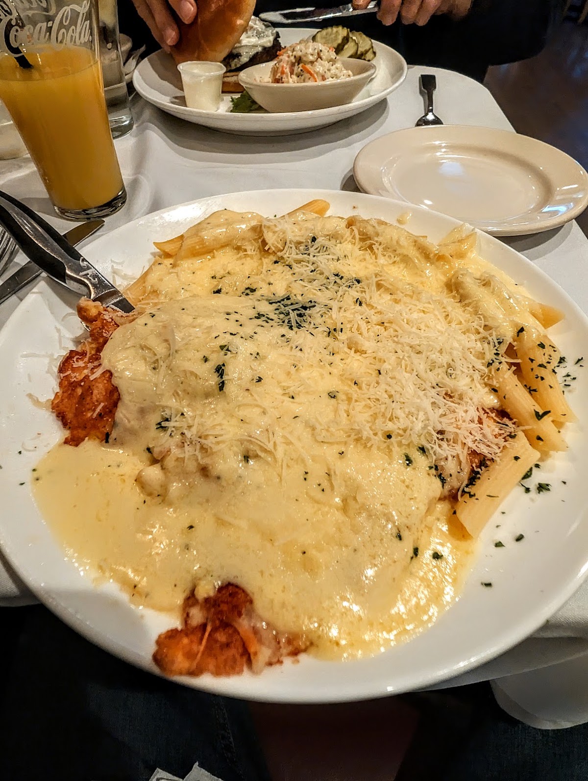 Breaded chicken entrée over penne pasta, topped with cream sauce and grated cheese