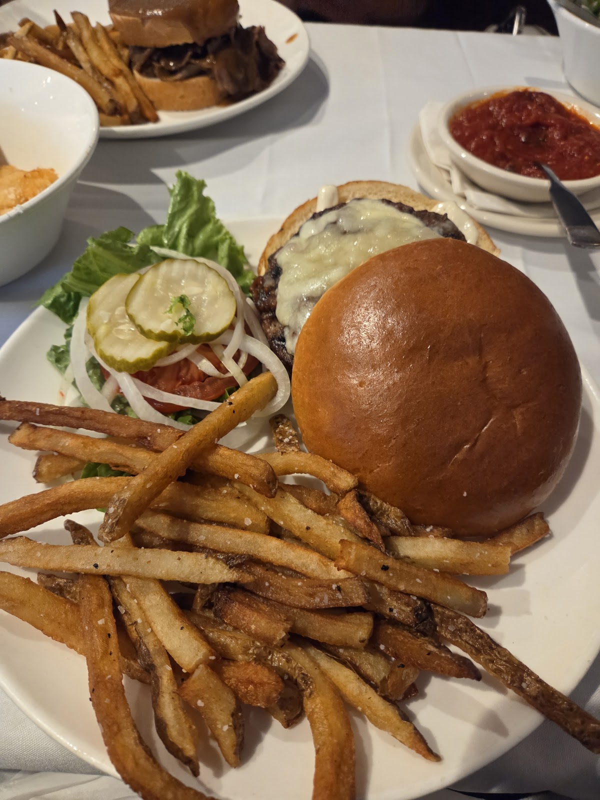 Cheeseburger on a brioche bun with hand-cut fries, lettuce, tomato, onion and pickles